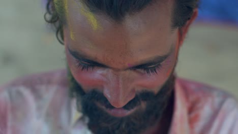 indian man close-up of face smeared with bright holi colors