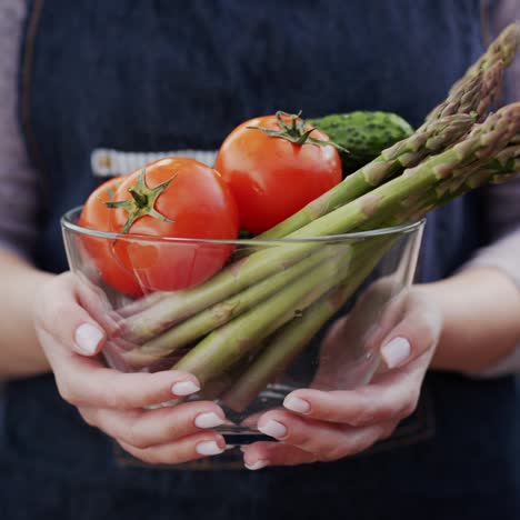 A-woman-holds-a-bowl-with-fresh-vegetables-1