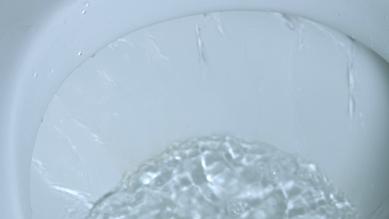 물이 변기 플러시에서 소용돌이 치며 청소하고 물이 변기에서 플러시됩니다.