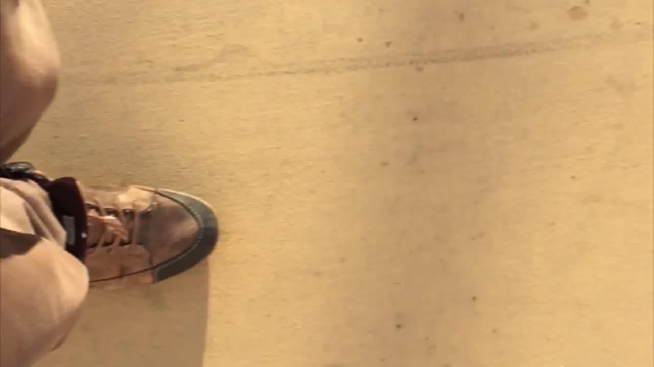 vista lateral cercana de piernas masculinas y zapatos grandes caminando en cámara lenta con sombra de amanecer