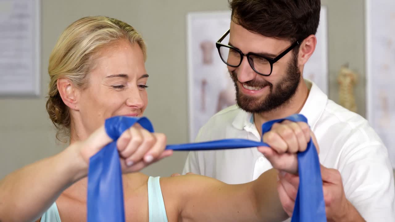 fisioterapeuta masculino dando masaje en el hombro a una paciente