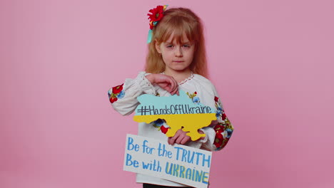 Sad-toddler-Ukrainian-girl-kid-in-embroidery-protesting-war-conflict-raises-banner-with-inscription