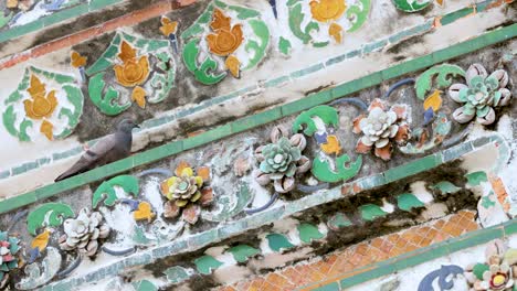 pigeon perched on ornate temple tiles