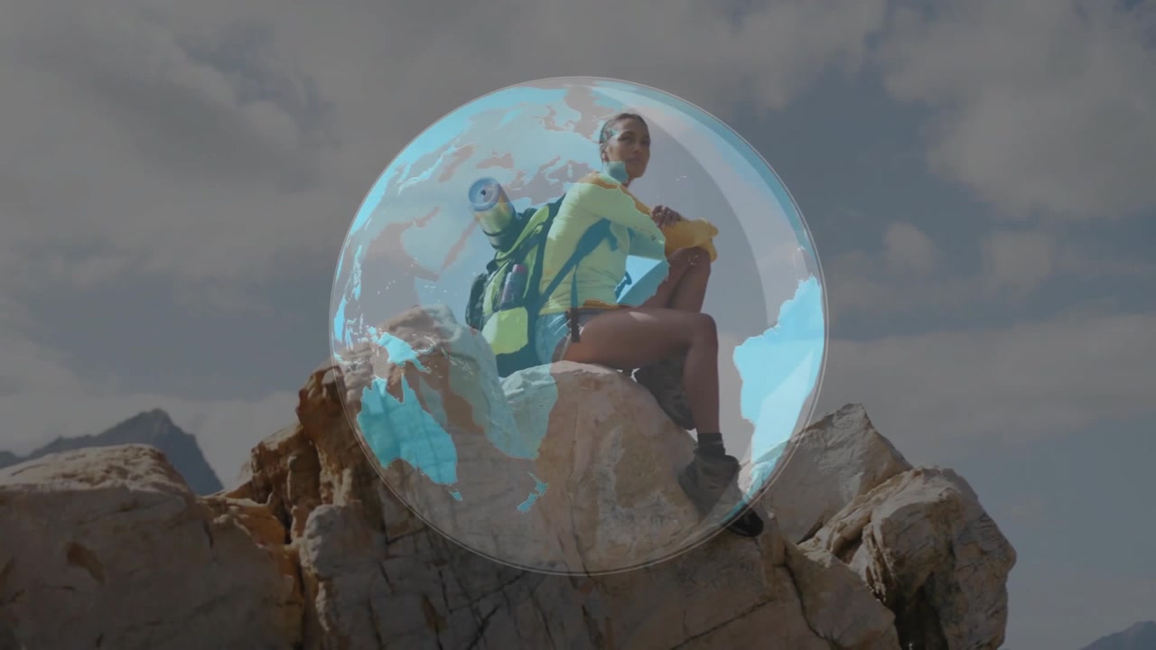 Excursionista sentada en la cima de una montaña con superposición de globo digital