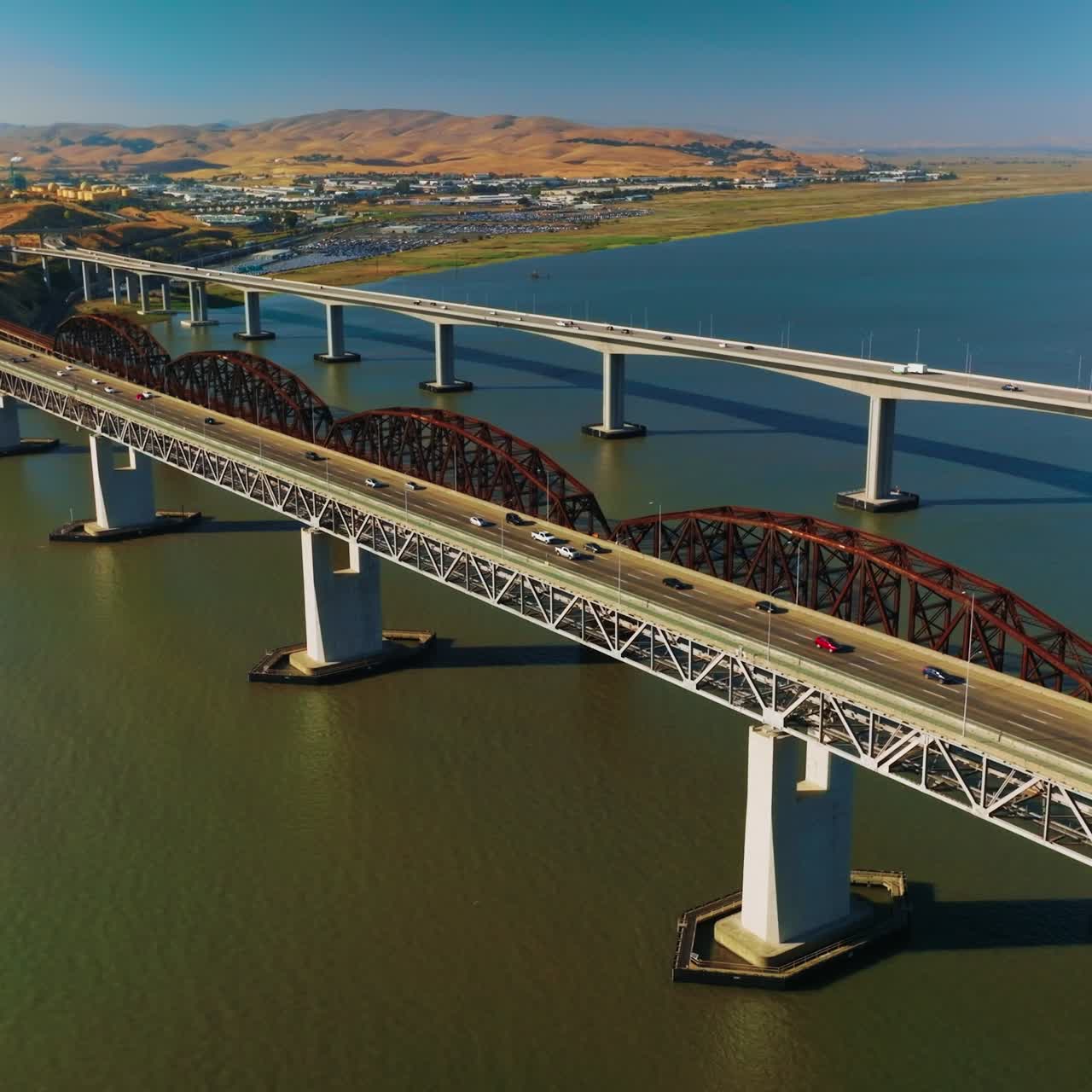 Bridges connecting Martinez to Benicia with transport moving by. Beautiful panorama of the strait and rocky landscape of Martinez, California on sunny daytime
