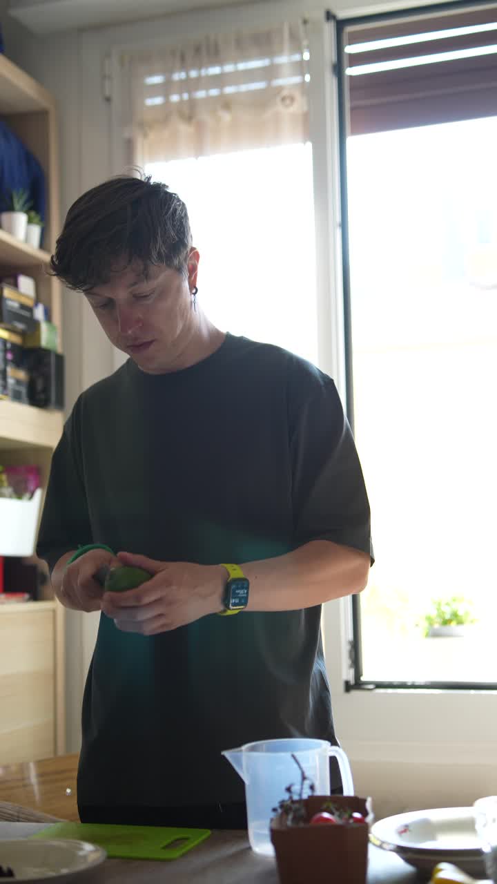 Man preparing an avocado in a kitchen