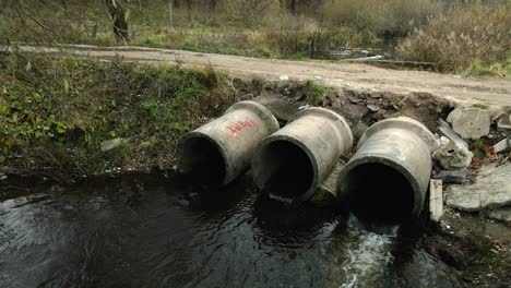 concrete waste pipes. streams of water flow through concrete pipes. polluted body of water in the park. shooting from the drone. aerial photography.