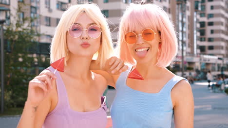 two friends with colorful hair and lollipops