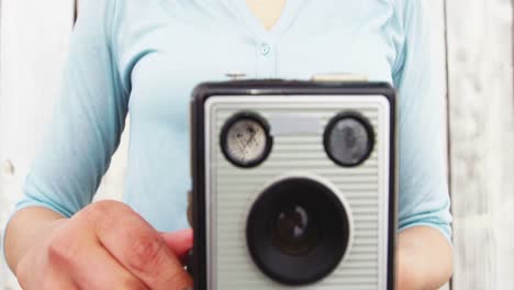 Close-up-of-photographer-taking-photo-with-vintage-camera