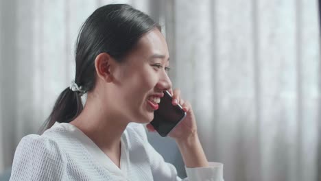 집에서 데스크에서 작업하는 동안 스마트폰으로 대화하는 하우스 모델과 함께 아시아 여성 엔지니어의 클로즈업