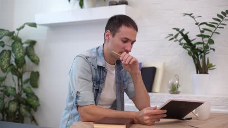 hombre trabajando con tableta en la mesa en casa