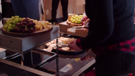 woman getting cheese and crackers from event platter