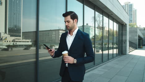 Closeup-businessman-walking-at-street.-Man-holding-take-away-coffee-outdoor