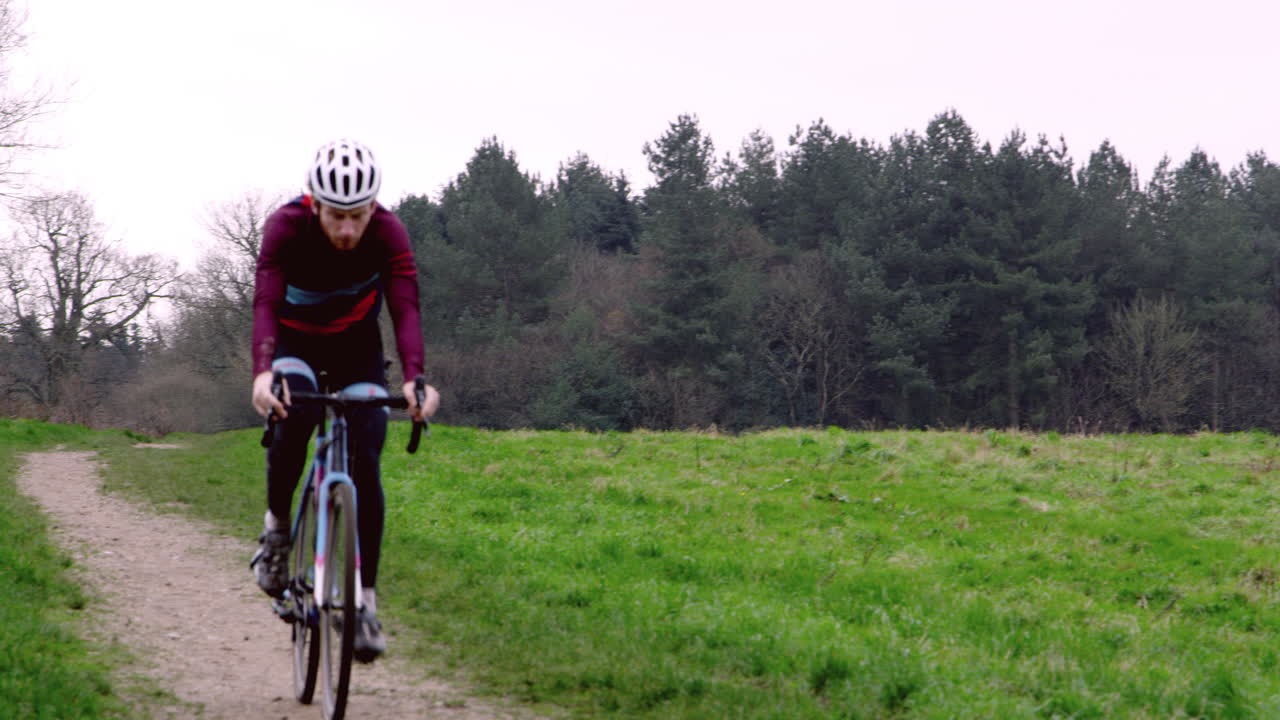 Ciclista cross-country che percorre un sentiero in aperta campagna, ripreso con R3D