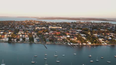 panorámica aérea que establece una visión general de la bahía botánica de san souci nsw australia con un cielo pastel suave