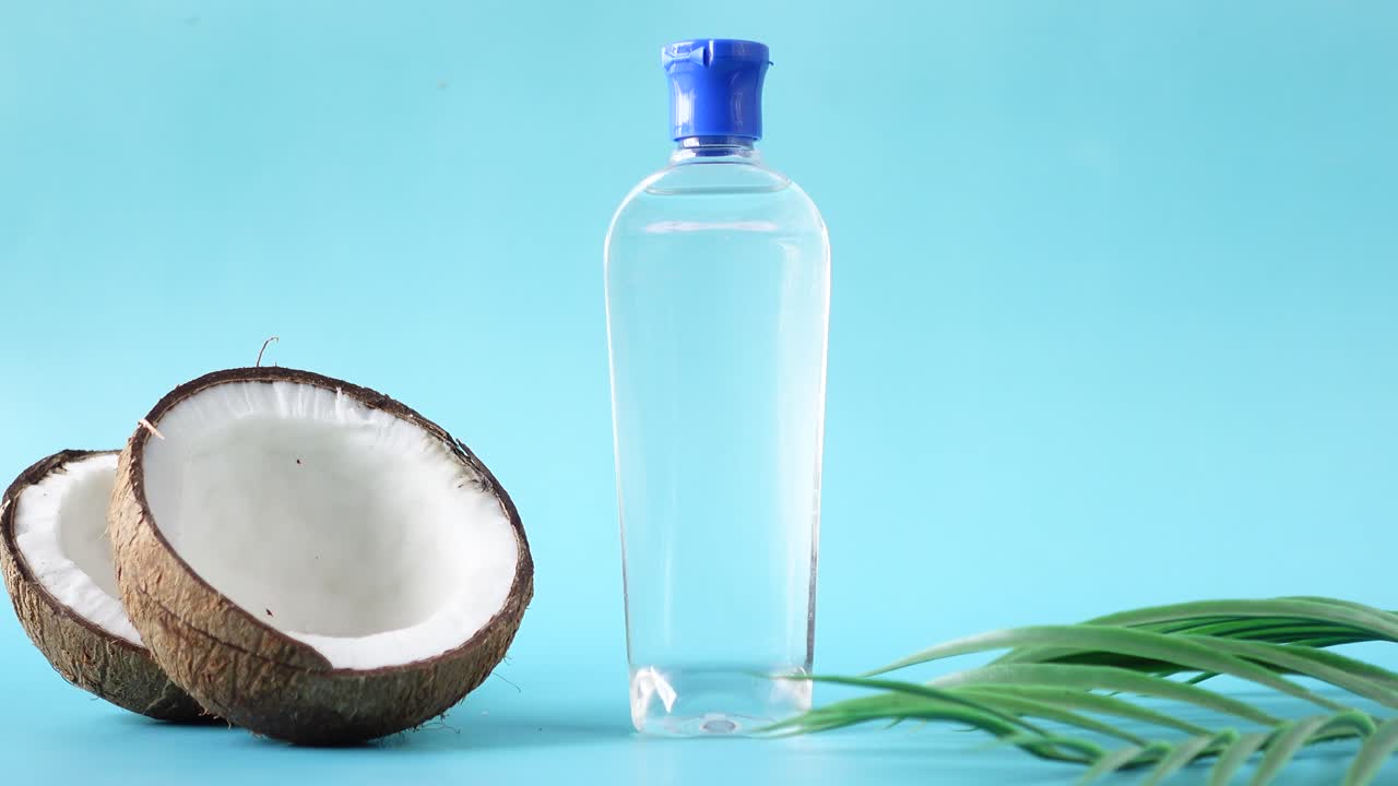 botella de aceite de coco con coco y hoja de palma