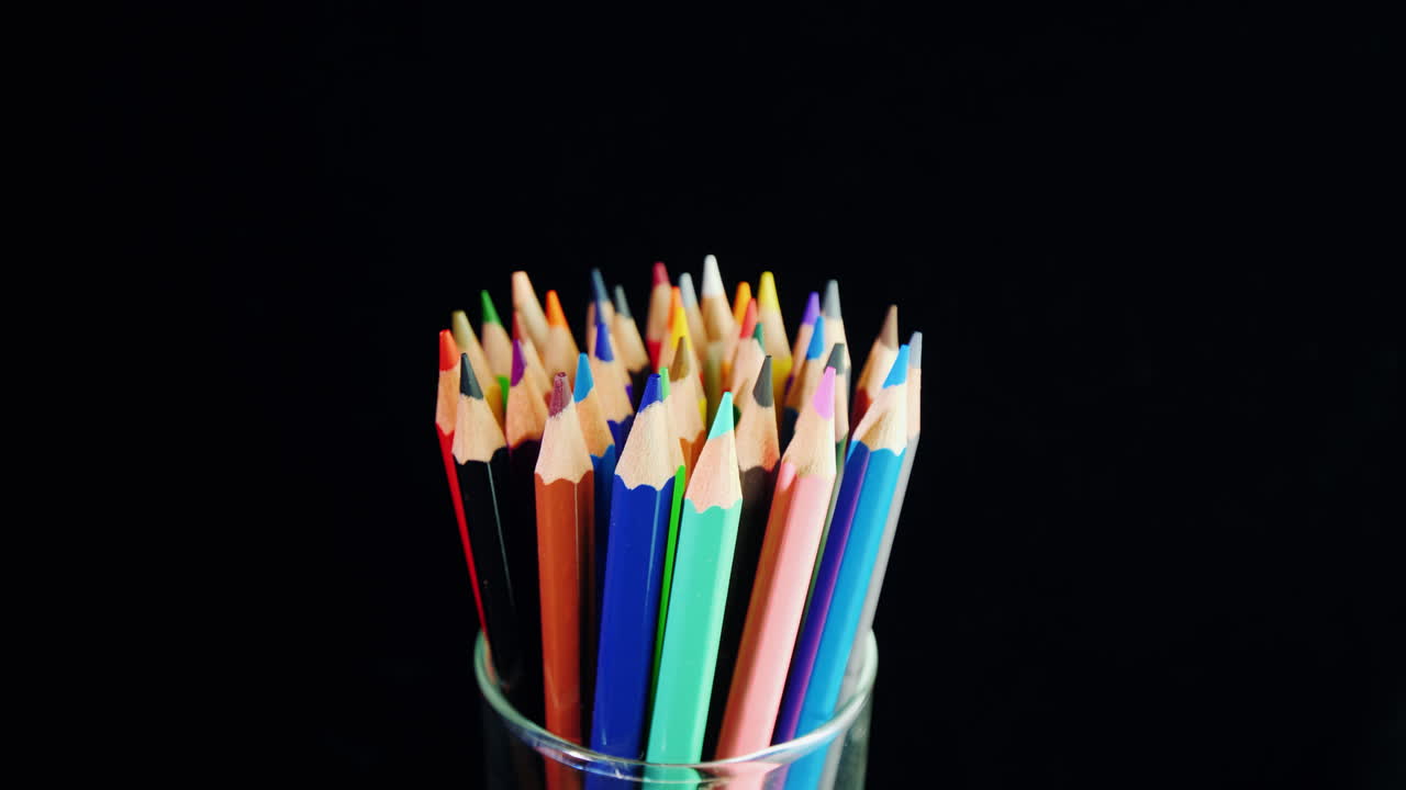 un juego de lápices multicolores sobre un fondo negro