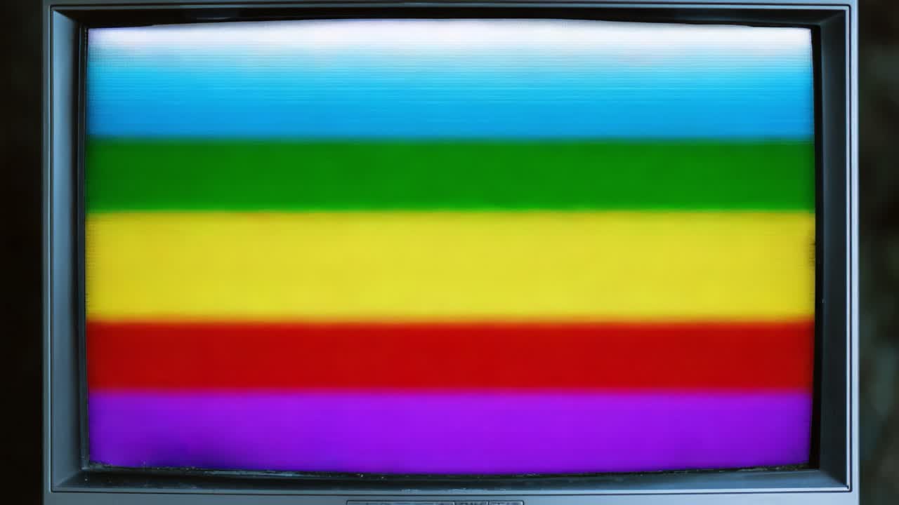 A vintage television displaying a distorted signal transitioning through vivid horizontal color bands, showcasing an artistic interpretation of visual noise and glitch art