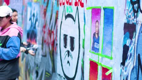 artist painting graffiti on melbourne's iconic wall