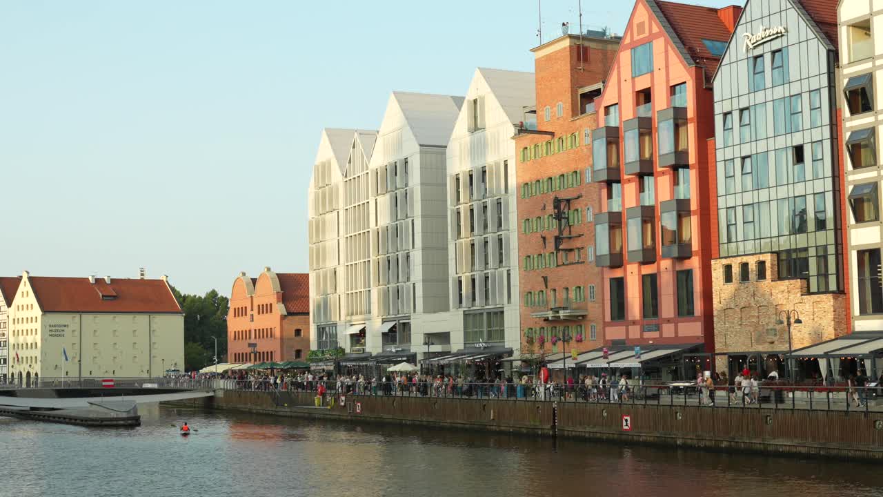 Busy promenade and luxury apartments along river in Gdansk city centre