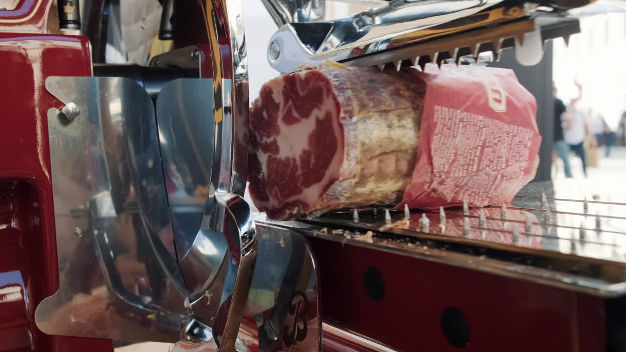 cortar el prosciutto en una máquina de cortar comercial