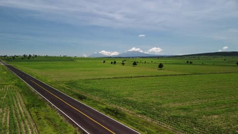 In-Tlaxcala,-Mexico,-a-drone-was-used-to-take-this-aerial-view-of-a-road-near-some-agricultural-fields