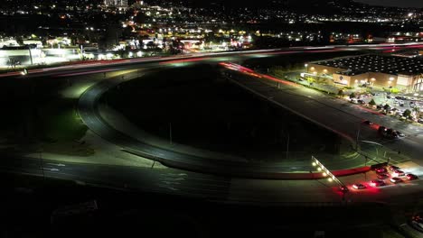 night time timelapse of the on-off ramp on california highway 10 redlands freeway merging with south tippecanoe ave in san bernardino busy traffic long exposure headlights aerial static