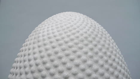 top portion of a huge granite seed-shaped sculpture at the heart of the core building at the eden project in cornwall, england, uk