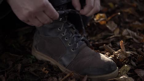 Excursionista-Atándose-Los-Cordones-De-Una-Bota-Para-Caminar-De-Tiro-Medio