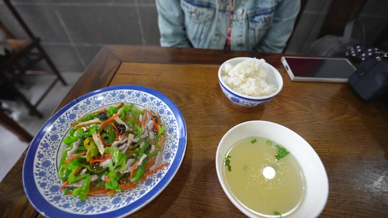 Bữa trưa truyền thống Trung Quốc với thịt xào, rau, cơm và canh trên bàn gỗ.