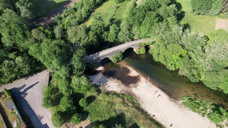 drone aéreo con movimiento hacia atrás volando sobre un puente medieval das partidas colocado sobre el río tea, en las afueras de la ciudad de ponteareas, españa