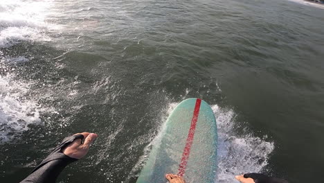 slow mo, pov gopro of surfer surfing on ocean wave on a summer day