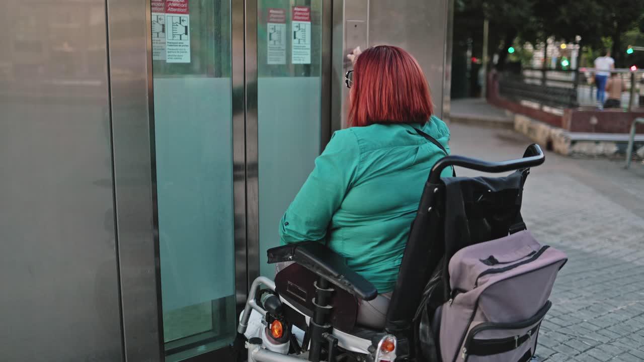 Woman in Electric Wheelchair Entering an Elevator in an Urban Setting