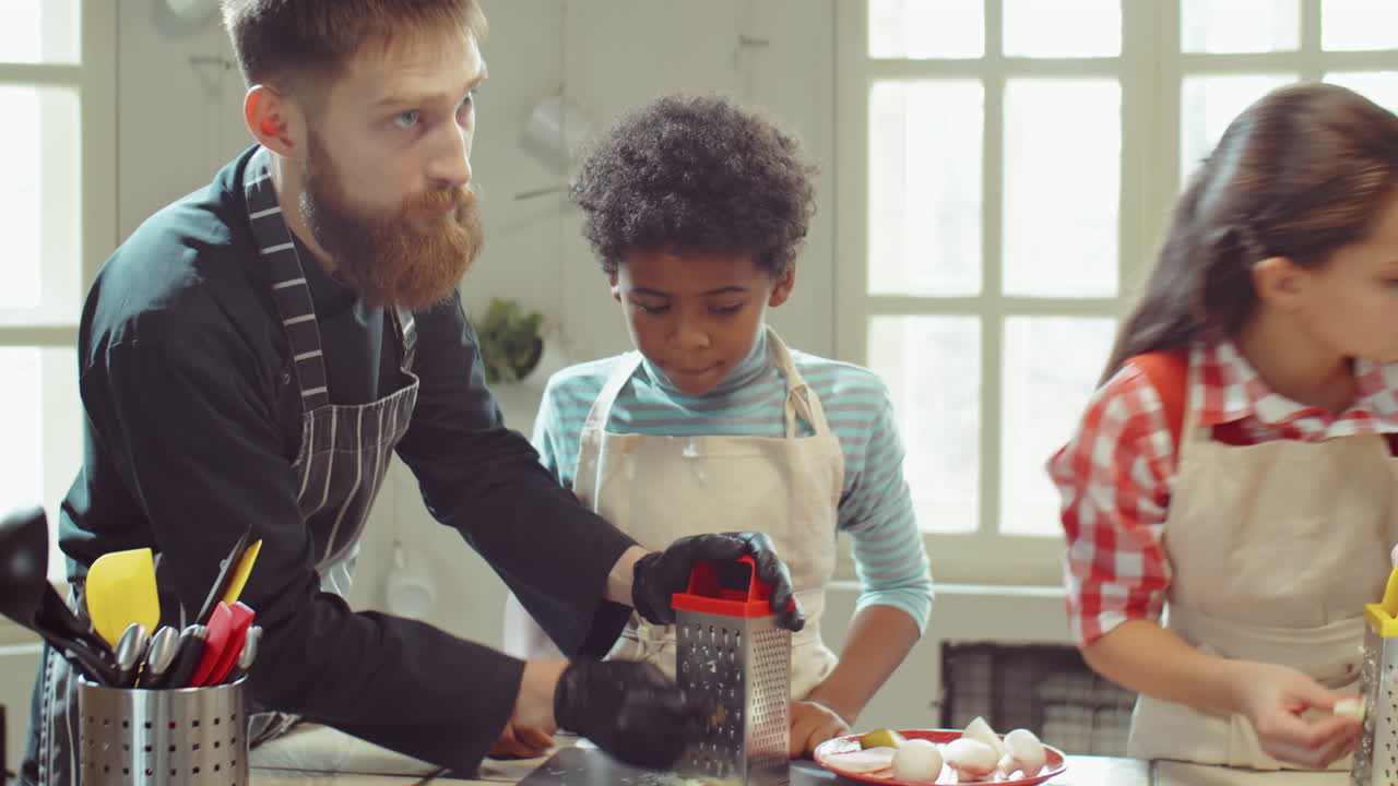 chef ayudando a los niños durante la clase magistral de cocina