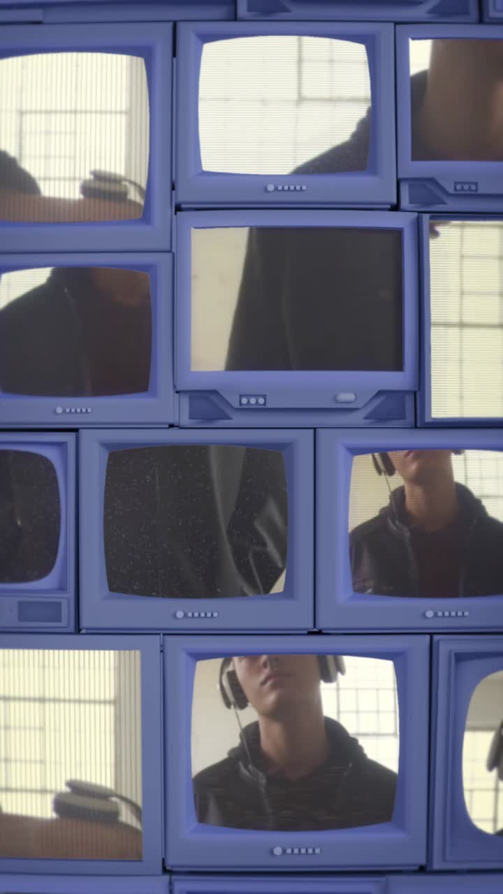 Young Man Reflected and Displayed on a Wall of Retro TV Screens