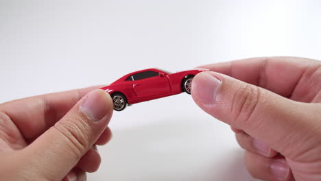 close-up of a toy, red sports car being turned around to see it in full view