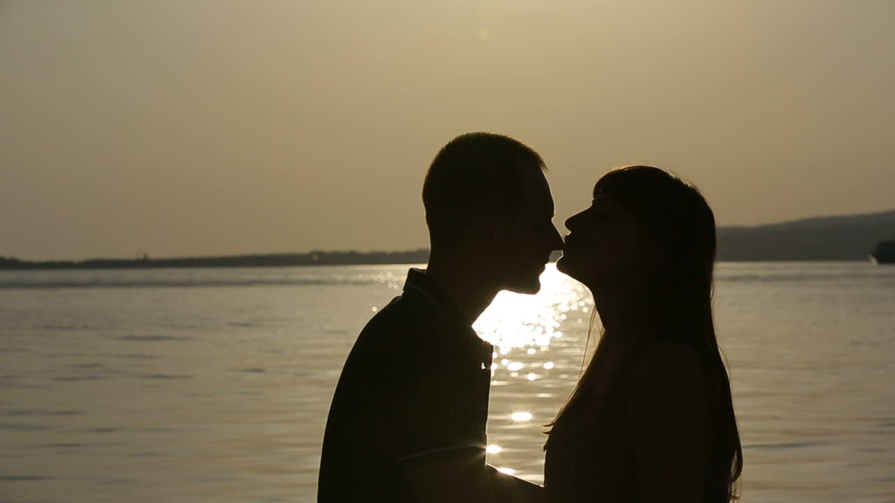Silhouette of romantic couple. Silhouette of happy couple lovers hugging at sunset