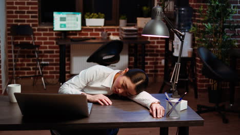 tired employee asleep on computer desk chair suddenly waking up