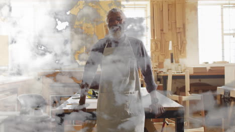 wearing apron, person in workshop with cloud animation overlay, focusing on task