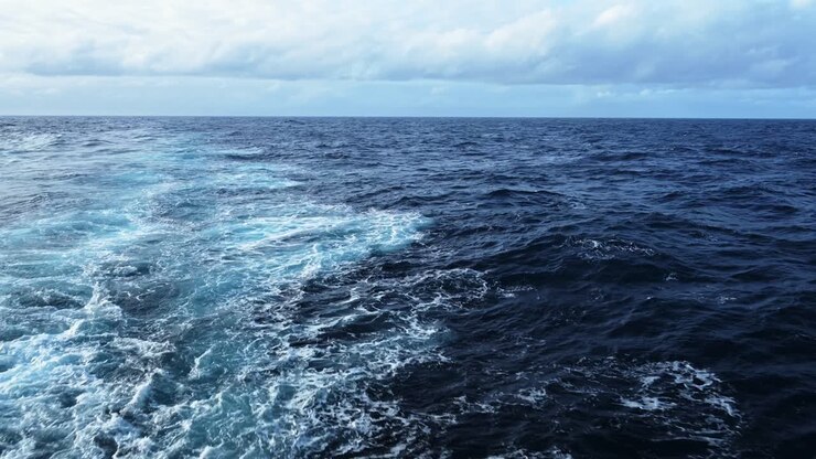 Open Ocean Ship View and Horizon, Gentle Rolling Swell of Waves and Sea Water with Clouds in Cloudy Weather, Vast Endless Sea Background with Copy Space from Moving Boat Cruise Ship Trip