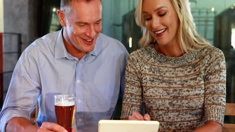 Paar-Nutzt-Digitales-Tablet-Beim-Biertrinken-In-Der-Bar-4k