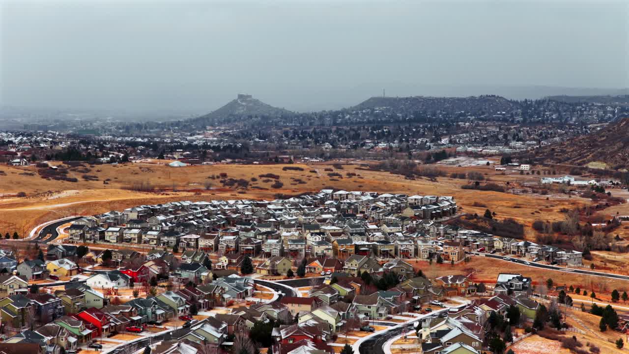 Colorado'daki Castle Rock'ın küçük mahalle kasabasının havadan drone görüntüsü; Güney Denver Front Range'de karla kaplı bir plato, arabalar, evler, binalar, karlı soğuk bir sabah, karlı ve bulutlu açık alan ve ileriye doğru hareket