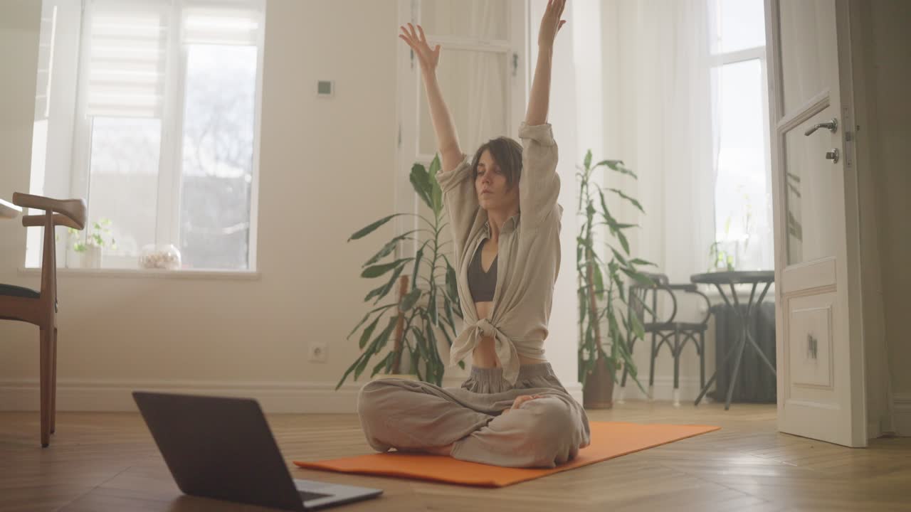 mujer practicando yoga en línea en casa
