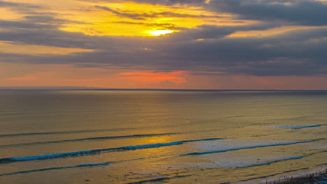 rolling waves on sunset beach with colorful sky. timelapse