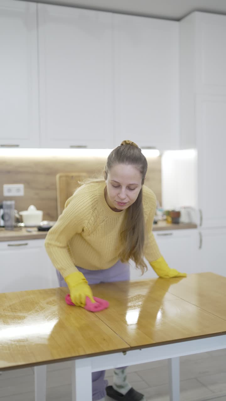 Video vertical que muestra a una mujer puliendo una mesa con un paño de microfibra, enfatizando el cuidado de las superficies, las tareas domésticas y la rutina de limpieza de primavera en interiores.
