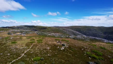 Dron-Panorámico-Mirando-A-Un-Grupo-De-Ciclistas-De-Montaña-En-La-Cima-De-Un-Pico-De-Montaña