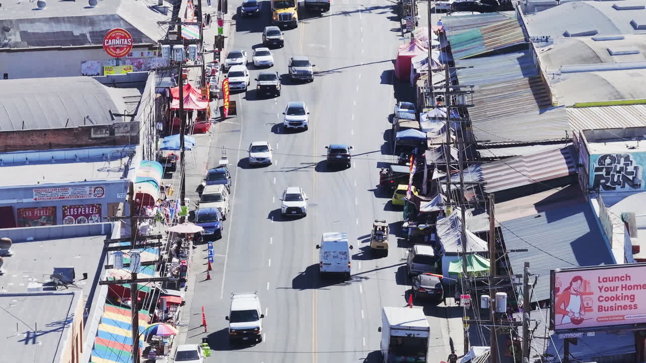 Aerial View of a Bustling City Street with Traffic and Shops