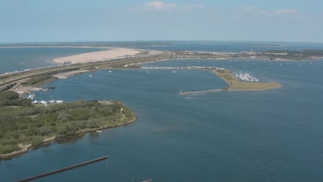 drone - toma aérea de surfistas y veleros en un mar azul, ondulado y ventoso en un día soleado con nubes blancas en una isla, 25p