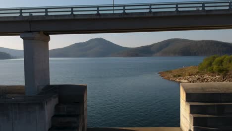 a unique perspective of scenic mountain waterway contained by large structured concrete dam.