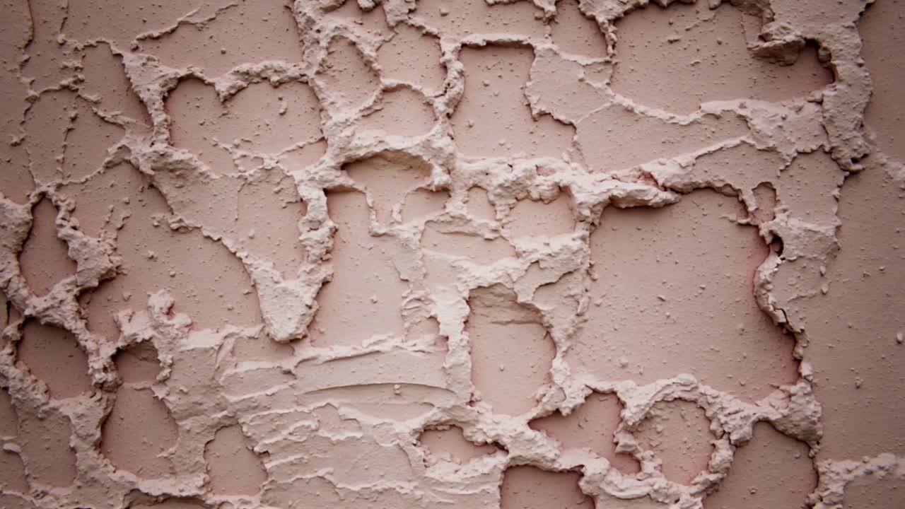 Drifting camera revealing textured plaster wall at close-up to emphasize trowel marks and pores